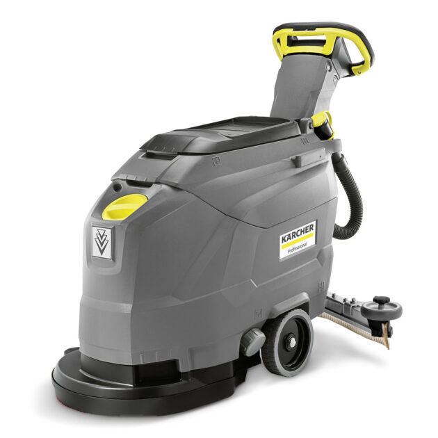 A modern commercial scrubber dryer by karcher, featuring a grey body with yellow handles, on-board storage for a scrubbing attachment, and large wheels for mobility.