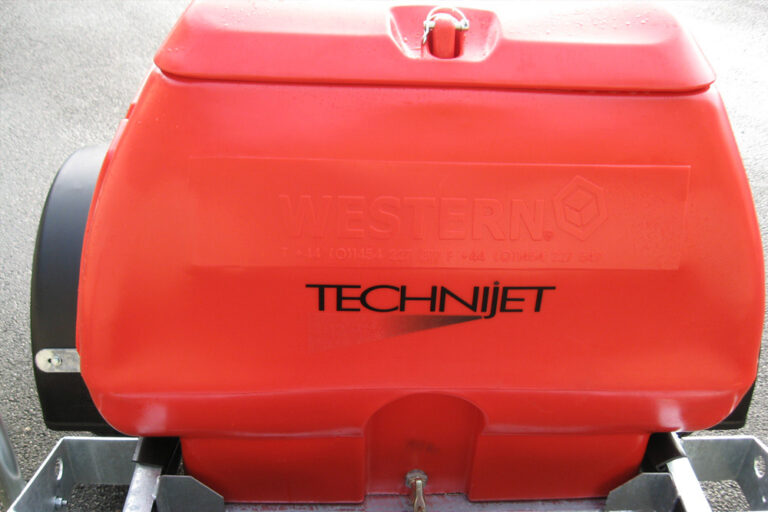 Close-up of a bright red western technijet industrial machine with embossed branding on its surface. the equipment appears to be part of a larger apparatus.