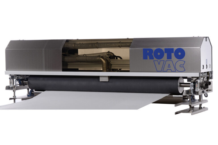 Industrial roto vac machine processing a large roll of paper on a white background.