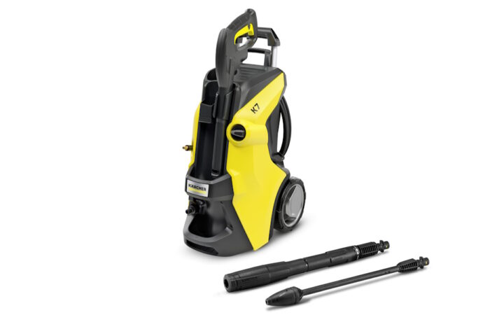 A yellow and black kärcher pressure washer with wheels and integrated handle, displayed alongside its nozzle attachments on a white background.